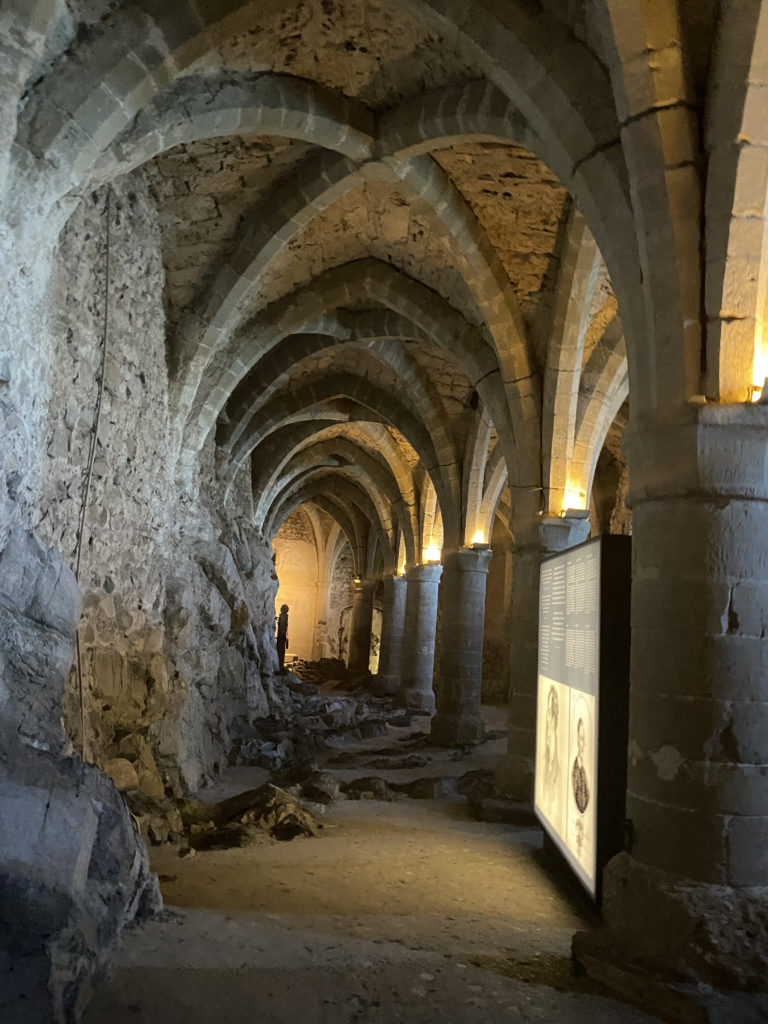 a stone tunnel with stone pillars and a sign