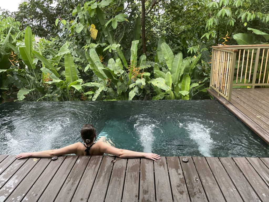 a woman in a pool with trees in the background