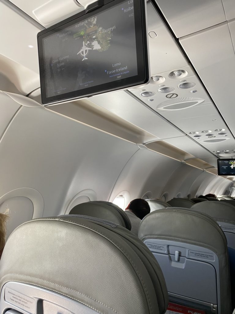 a screen on the ceiling of an airplane