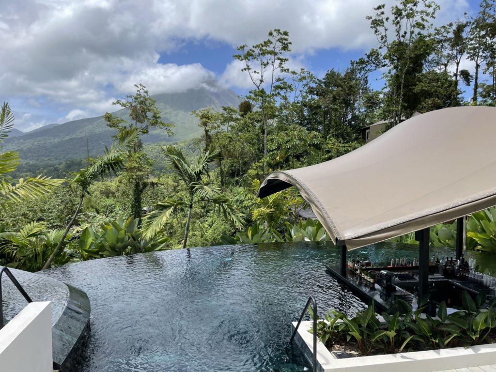 a pool with a bar and a mountain in the background
