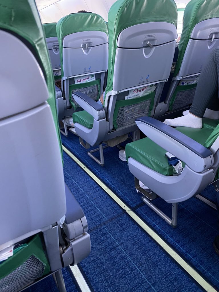 a person's feet on a seat in an airplane