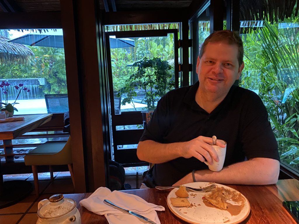 a man sitting at a table with food on it