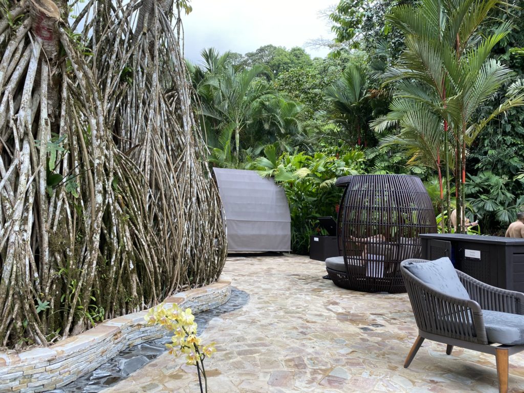 a patio with a water fountain and chairs