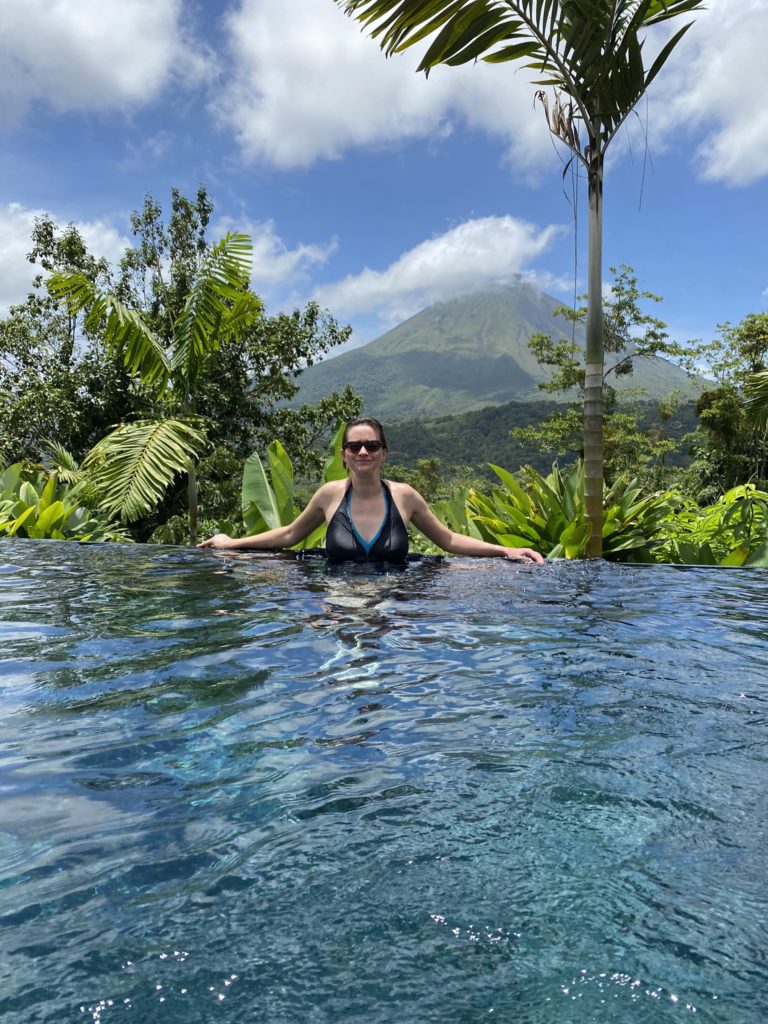 a woman in a pool with a mountain in the background