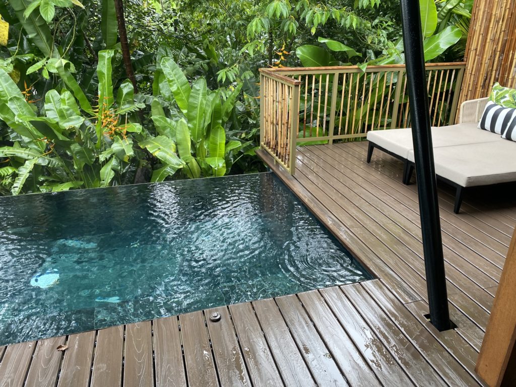 a pool on a deck with a deck and a deck with a bench