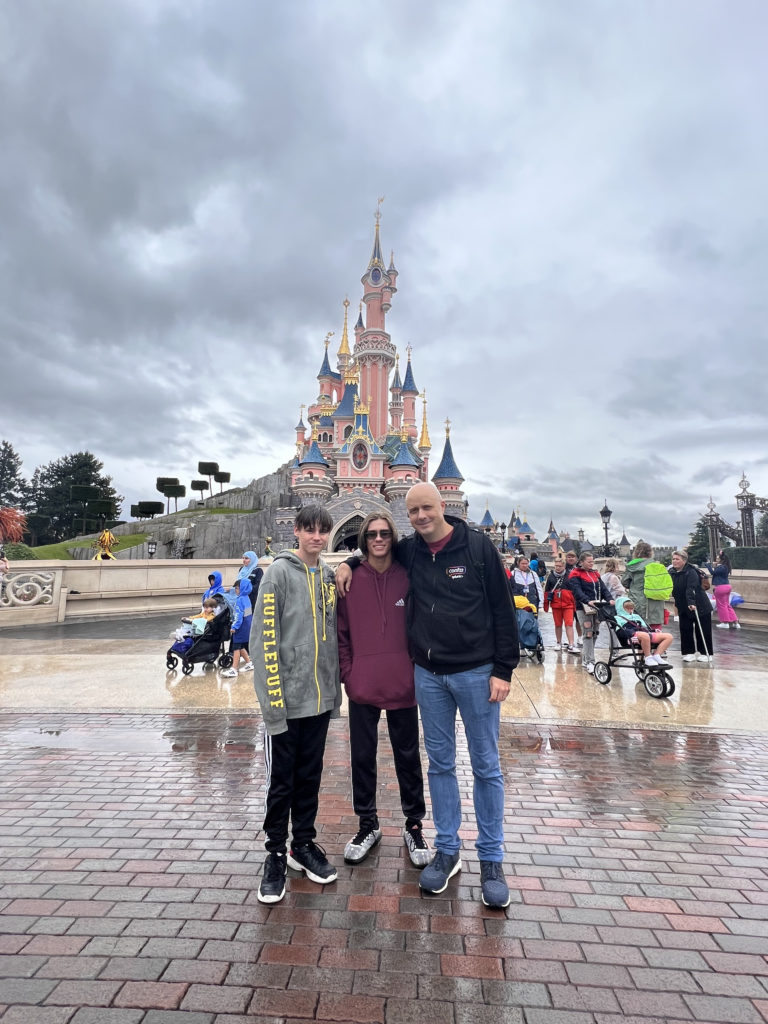 a group of people posing for a picture in front of a castle