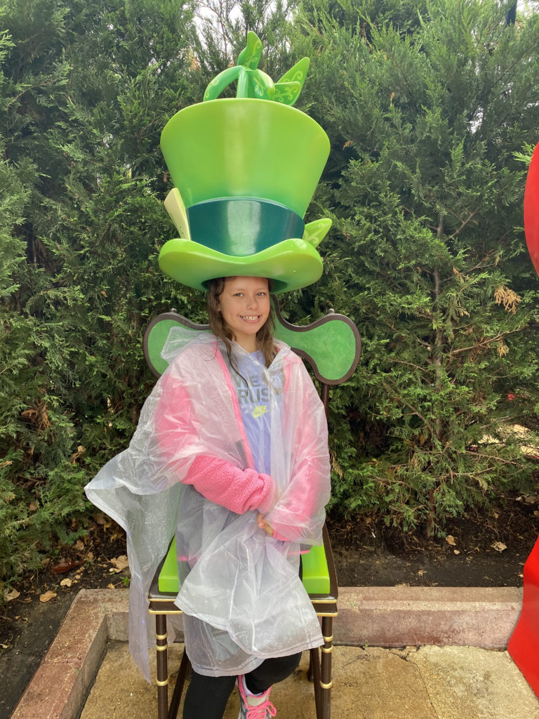 a girl sitting in a chair wearing a hat