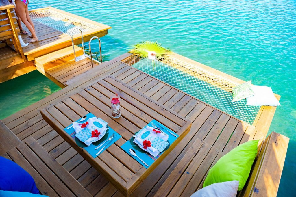 a table with plates and plates on it next to a pool