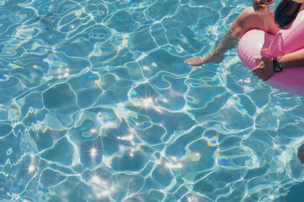 a person in a pool with a pink float