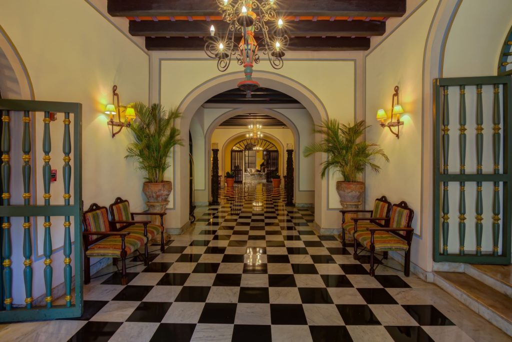 a hallway with chairs and a chandelier