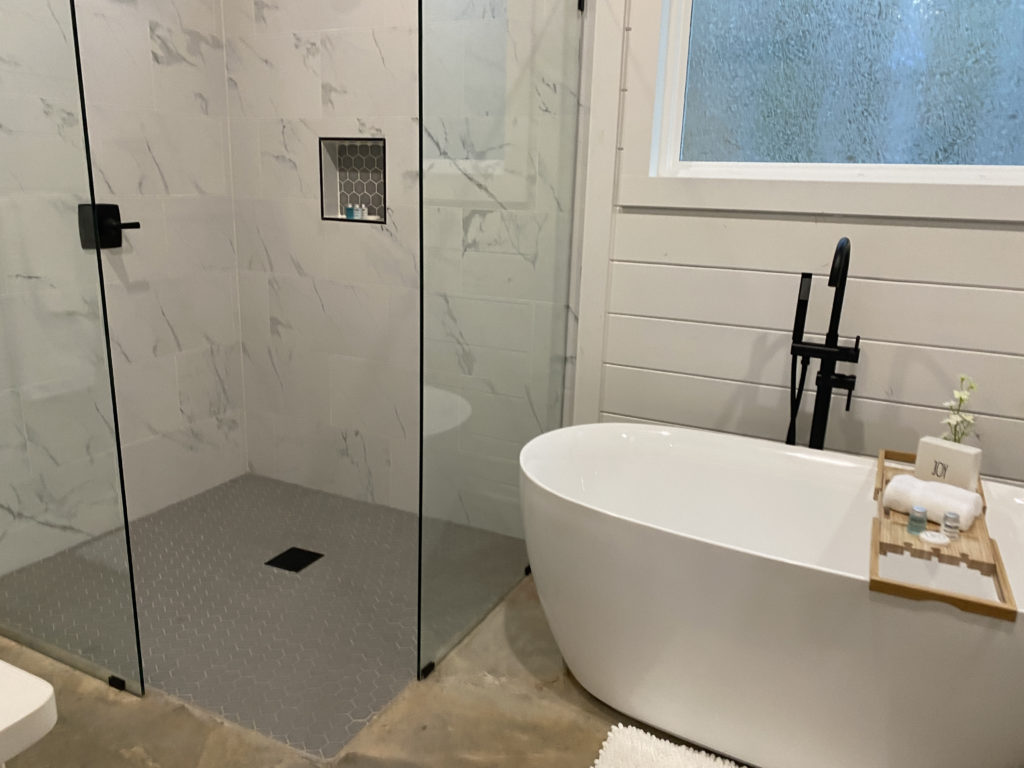 a bathroom with a glass shower and tub