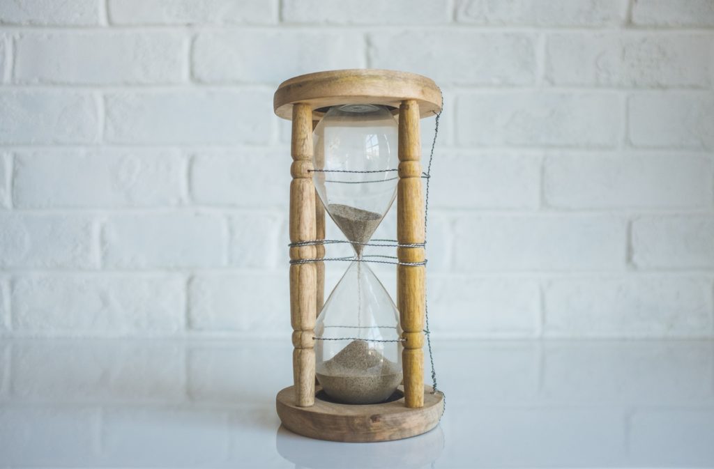 a sand glass with wood legs