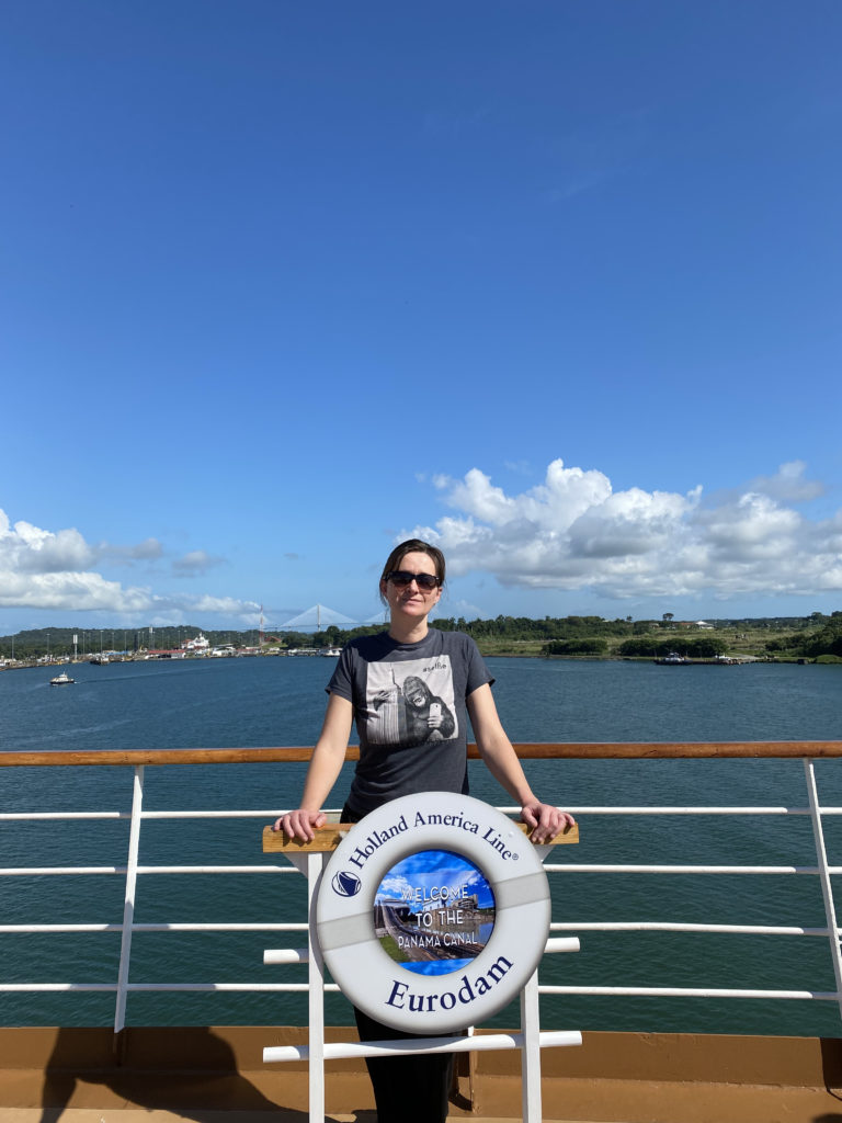 a woman standing on a deck with a life preserver on the railing