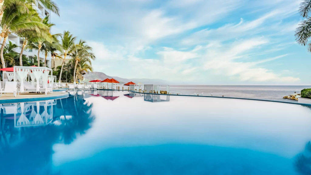 a pool with umbrellas and palm trees