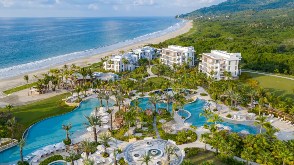 a resort with palm trees and a beach