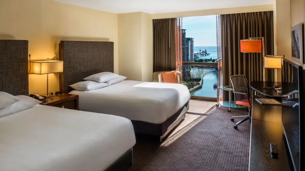 a hotel room with two beds and a chair and a table