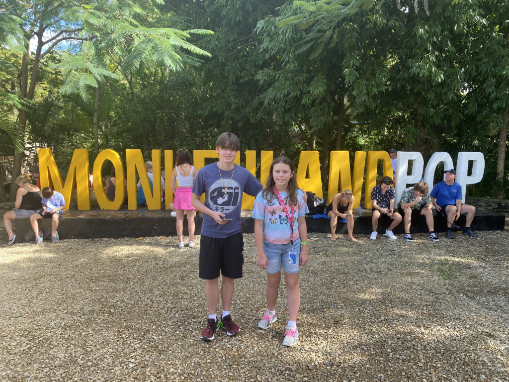 a boy and girl standing in front of a sign
