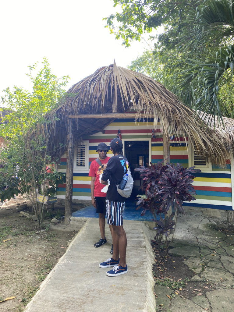 two men standing outside a hut