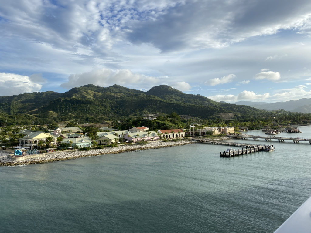 a body of water with buildings and mountains in the background