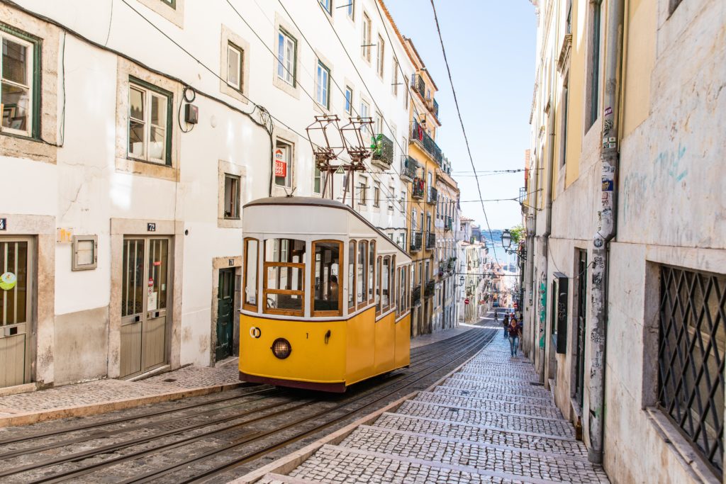 a yellow trolley on a narrow street