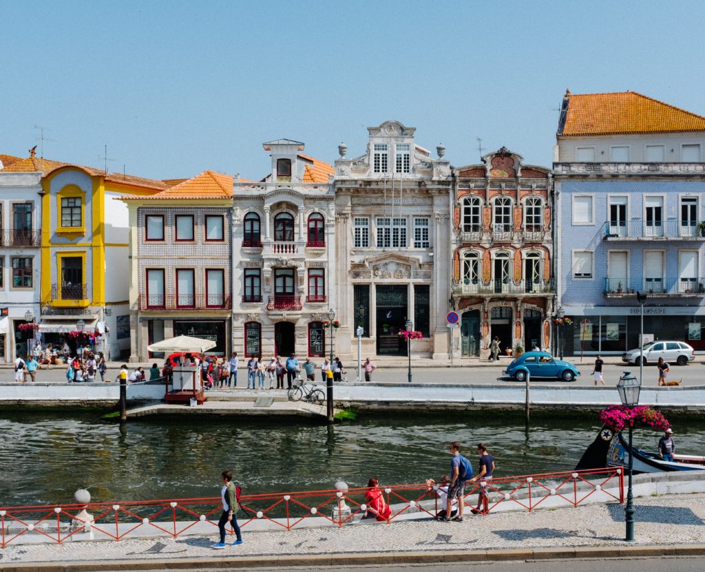a group of people walking on a sidewalk next to a canal