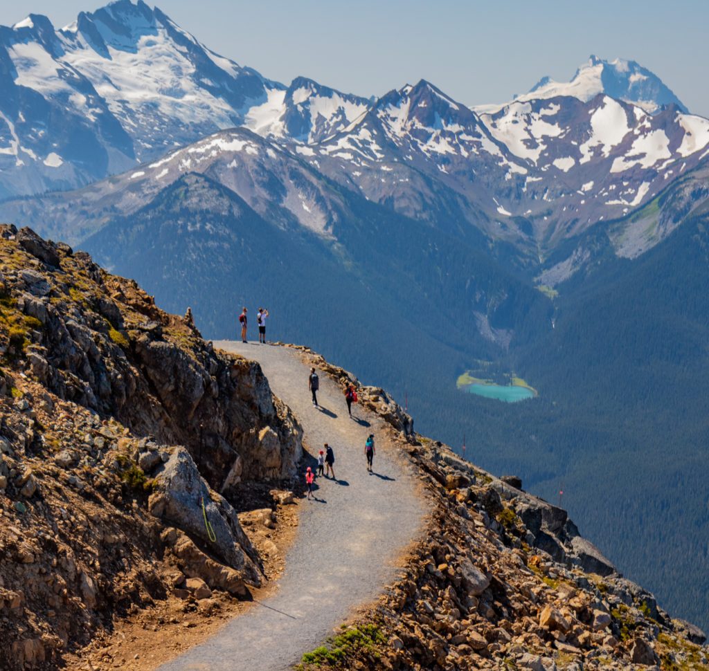 a group of people walking on a mountain path