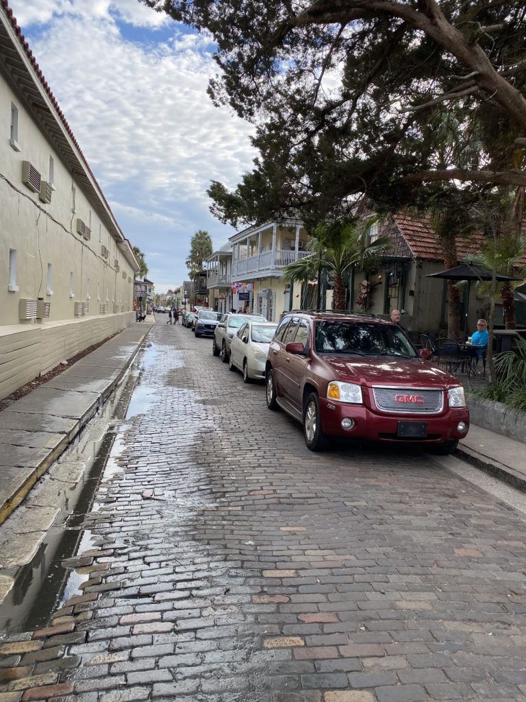 a row of cars parked on a brick street
