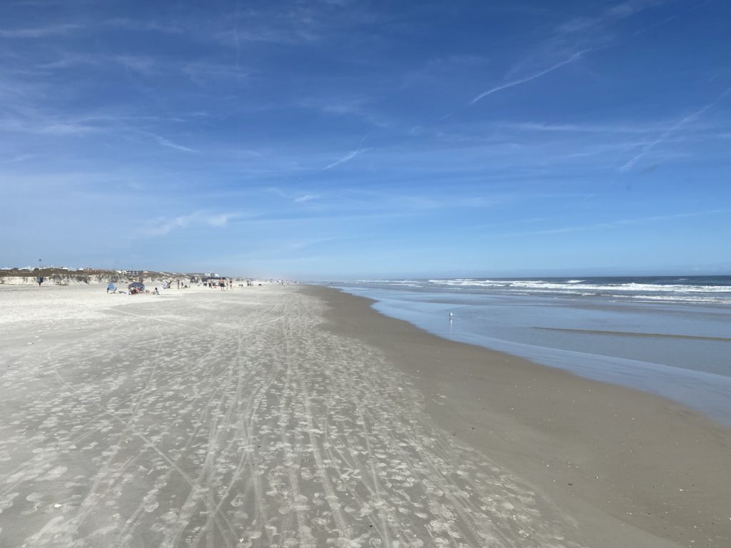 a beach with people walking on it