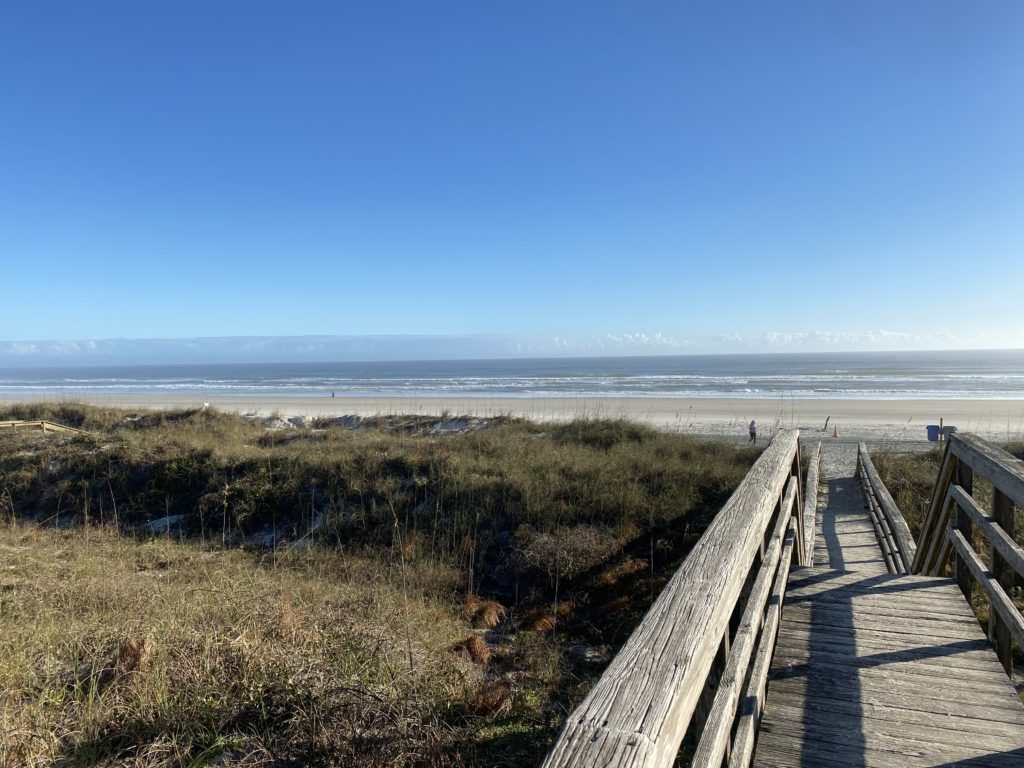 a wooden walkway leading to a beach