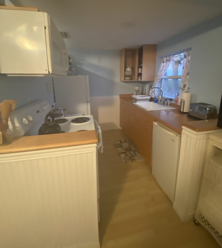 a kitchen with white appliances and a wood floor