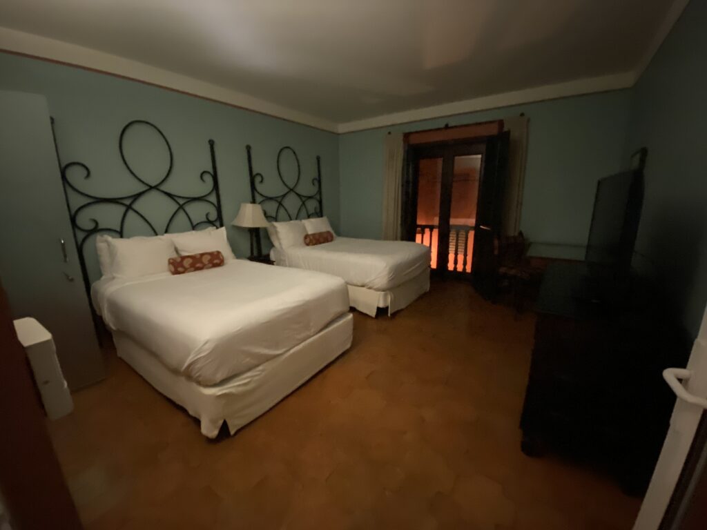 a room with two beds and a television
