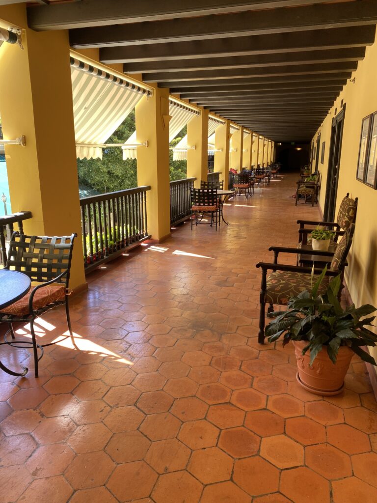 a long hallway with chairs and a plant
