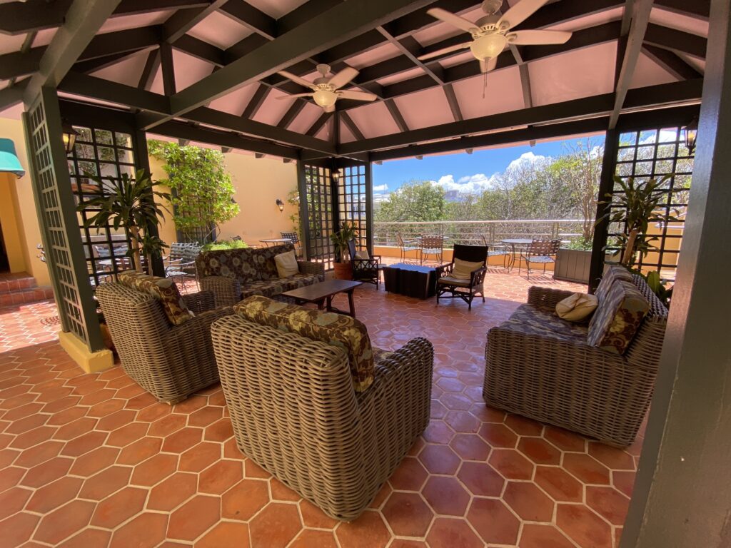 a patio with chairs and a ceiling fan