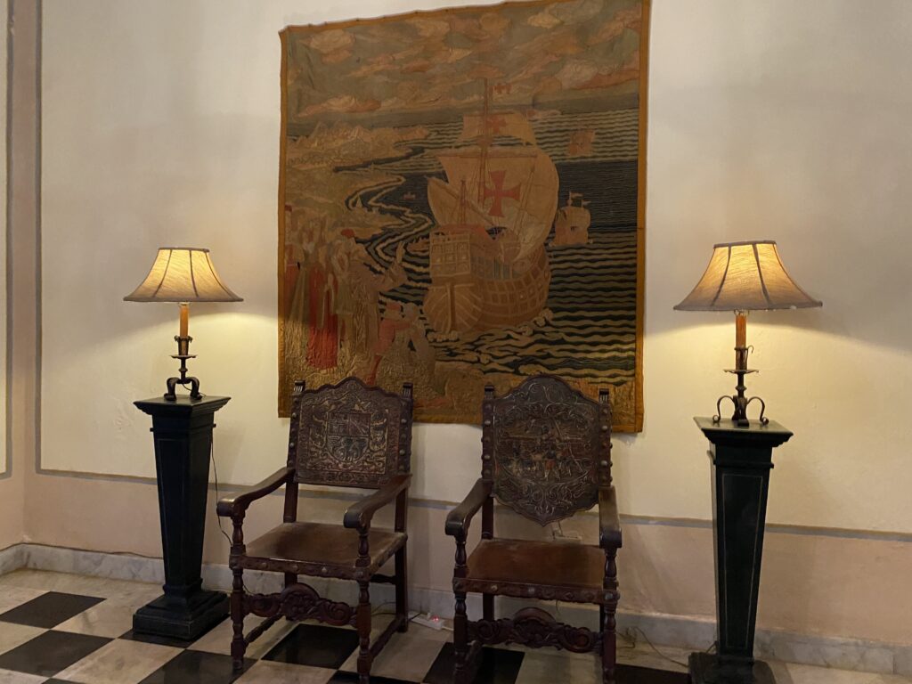 two chairs next to a tapestry
