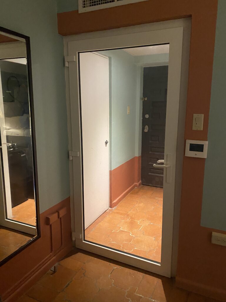 a door with a mirror in the middle of a hallway