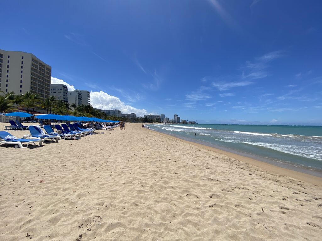 a beach with chairs and umbrellas