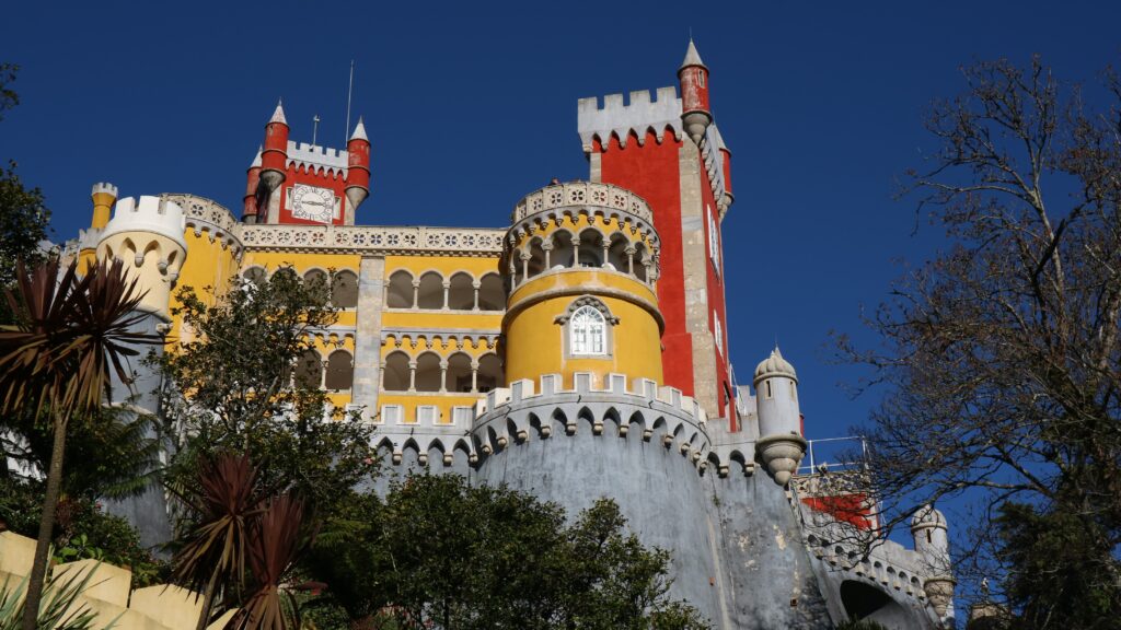 a castle with towers and trees with Pena Palace in the background
