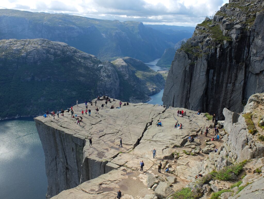 a group of people on a cliff with Preikestolen in the background