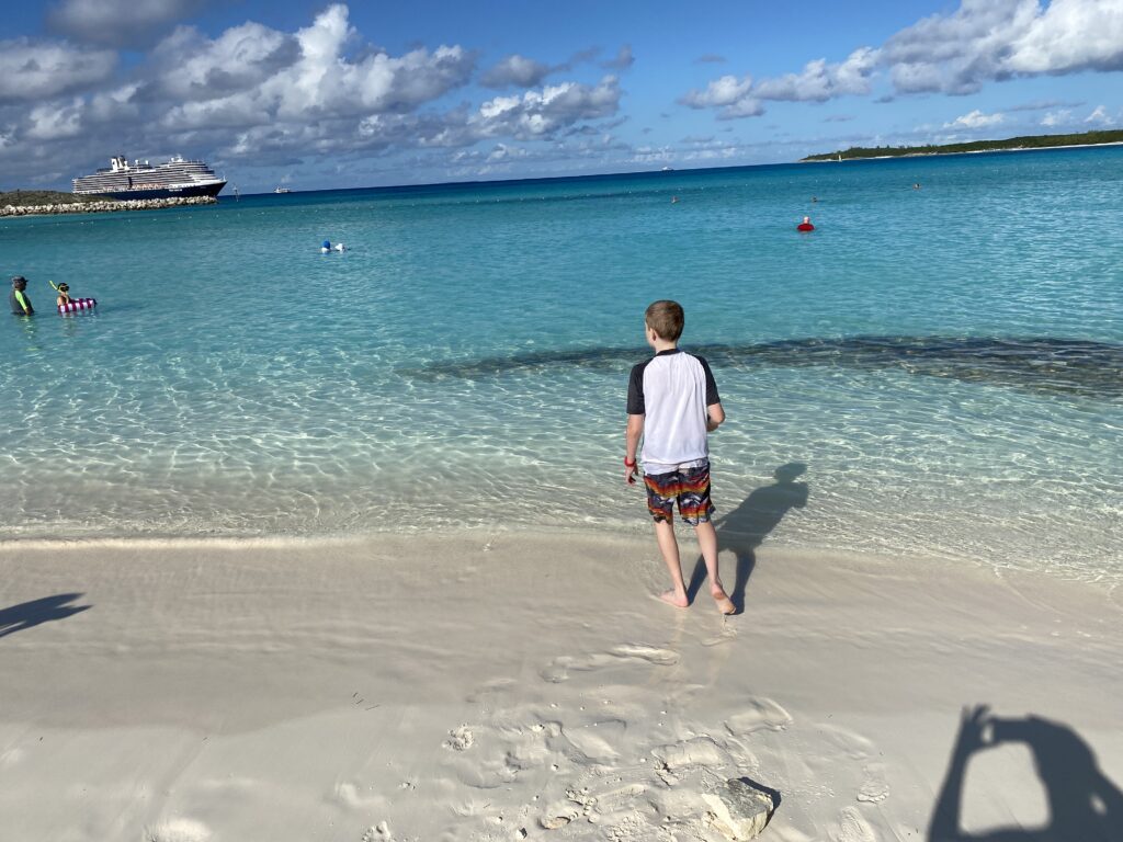 a boy standing on a beach