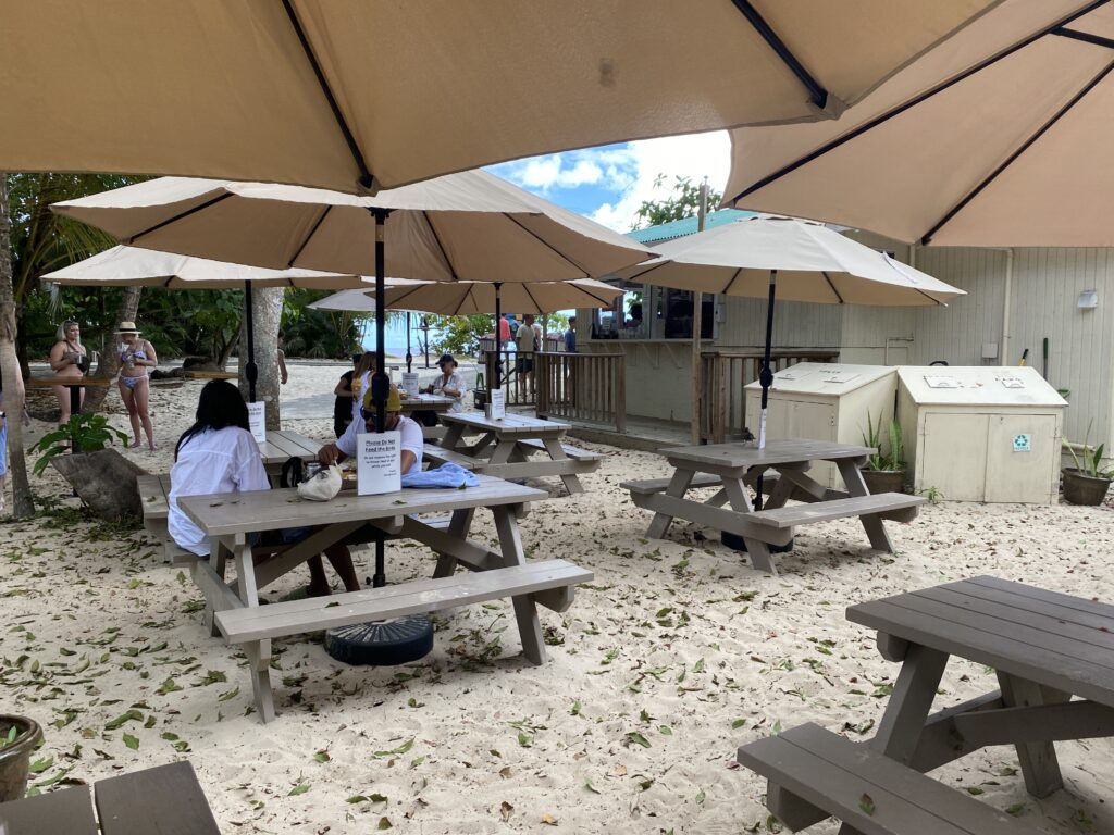 people sitting at a table under umbrellas