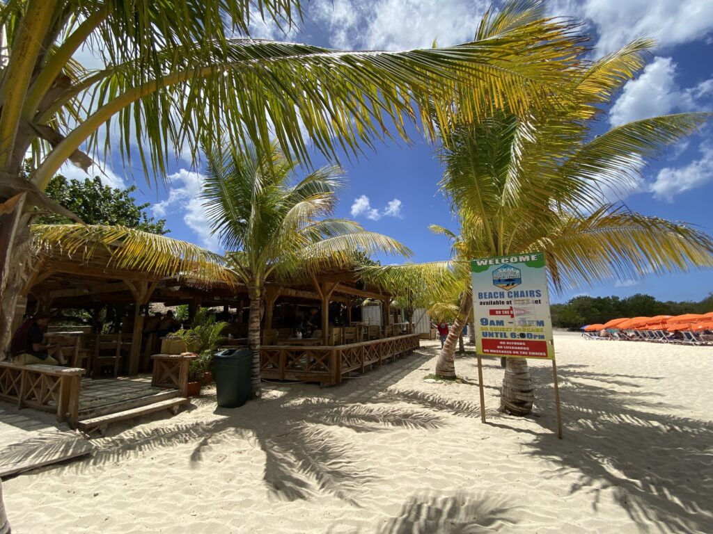a beach with palm trees and a sign