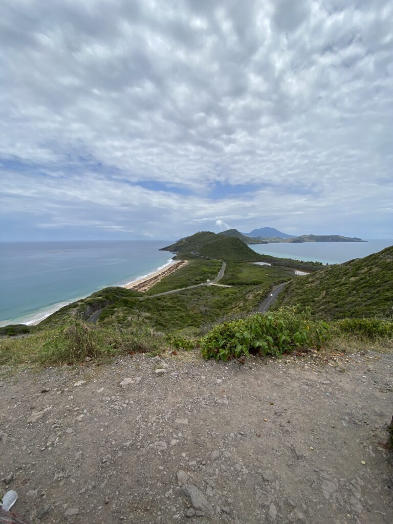 a road on a hill with a body of water and mountains