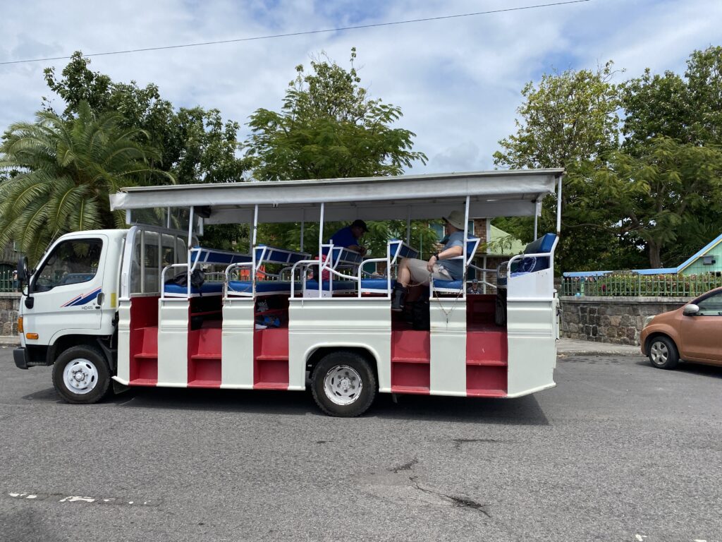 a white and red bus with people sitting on it