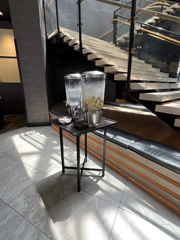 a drink dispenser on a table with a staircase