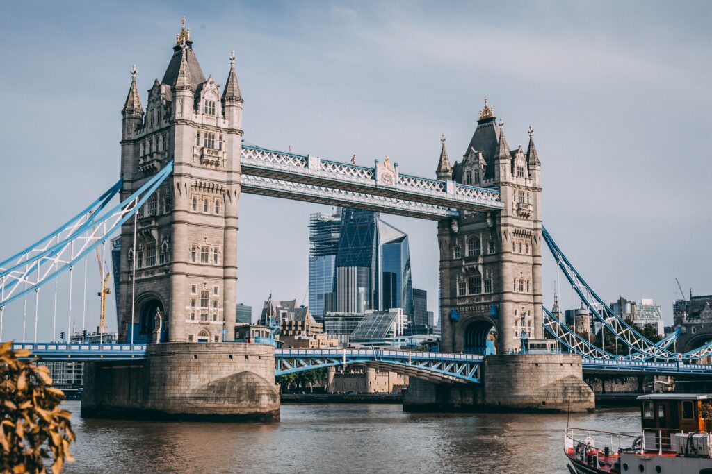 a bridge over water with towers and a boat