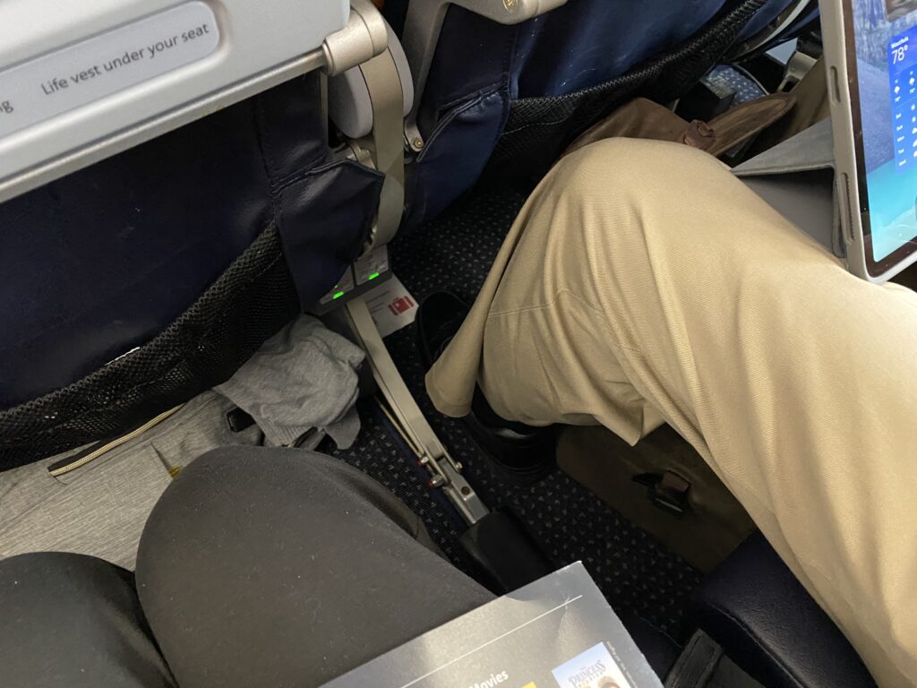a person's legs in the seat of an airplane