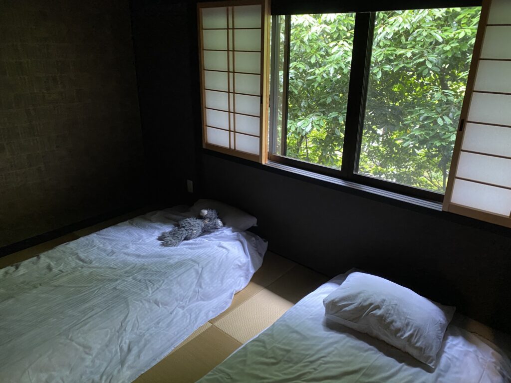 two beds in a room with a window and trees