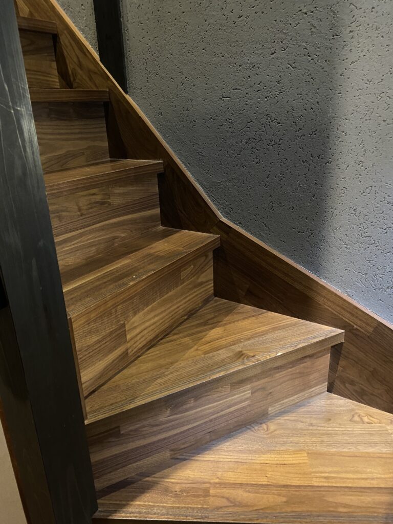 a wooden stairs with a black post