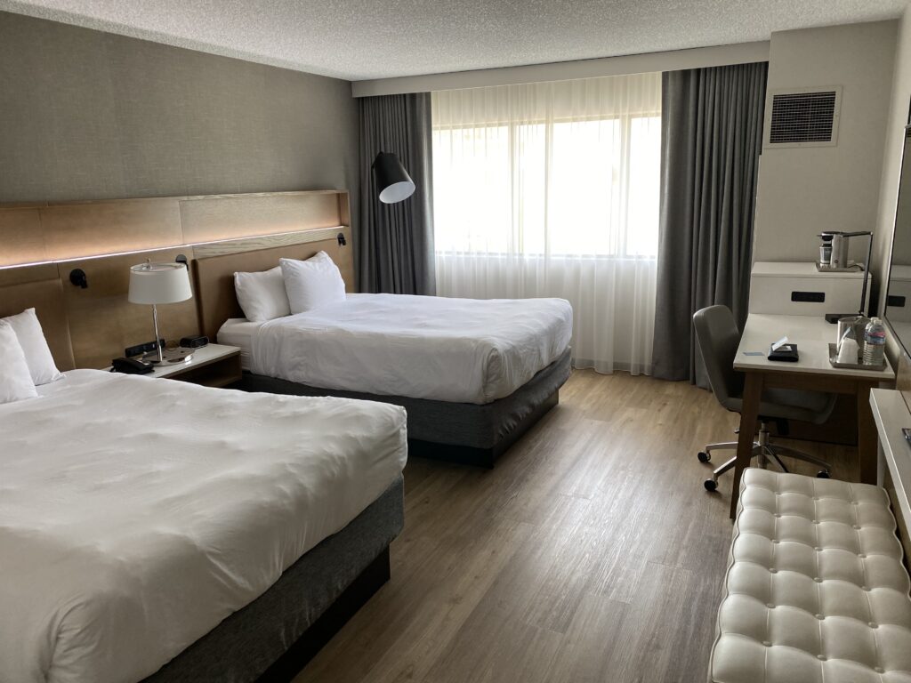 a room with two beds and a desk
