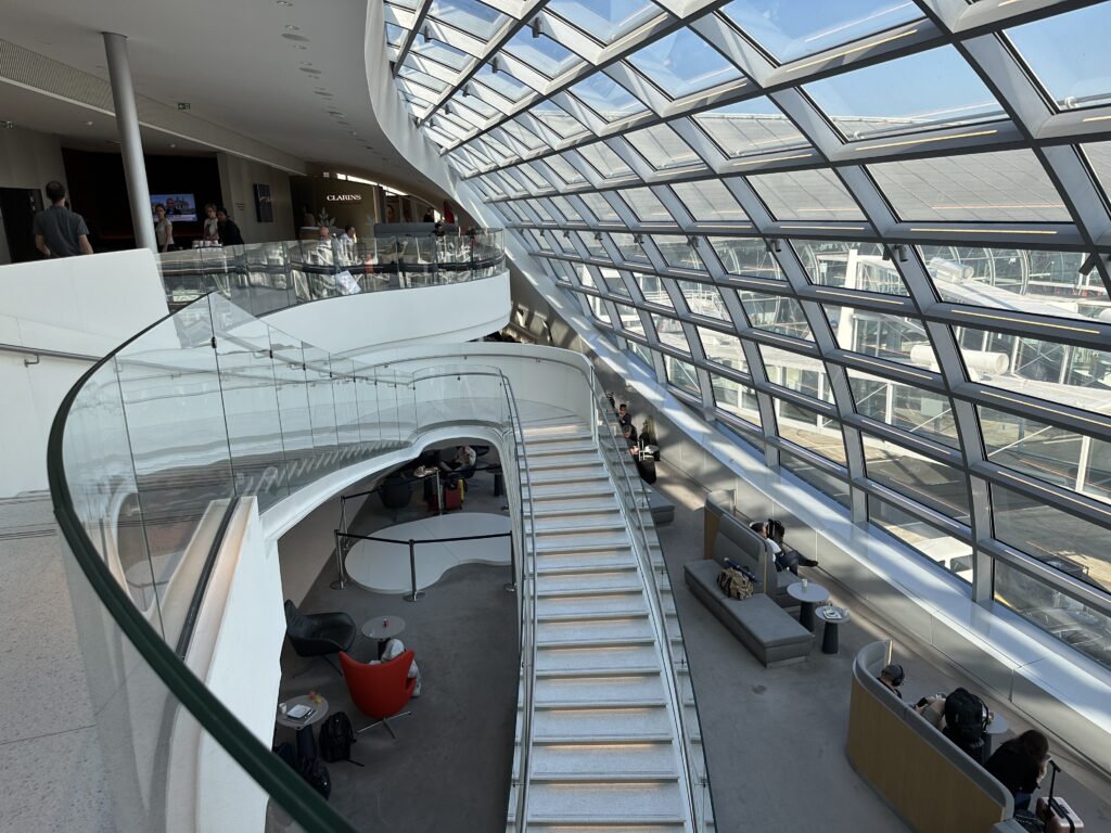 a glass ceiling with people sitting on benches and stairs